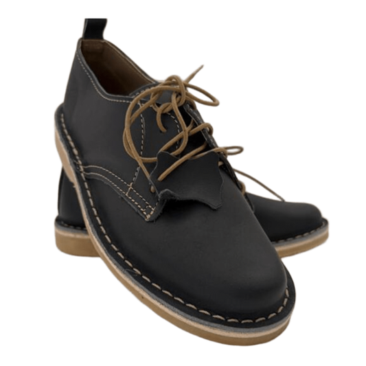 Black leather shoe with brown laces on a white background