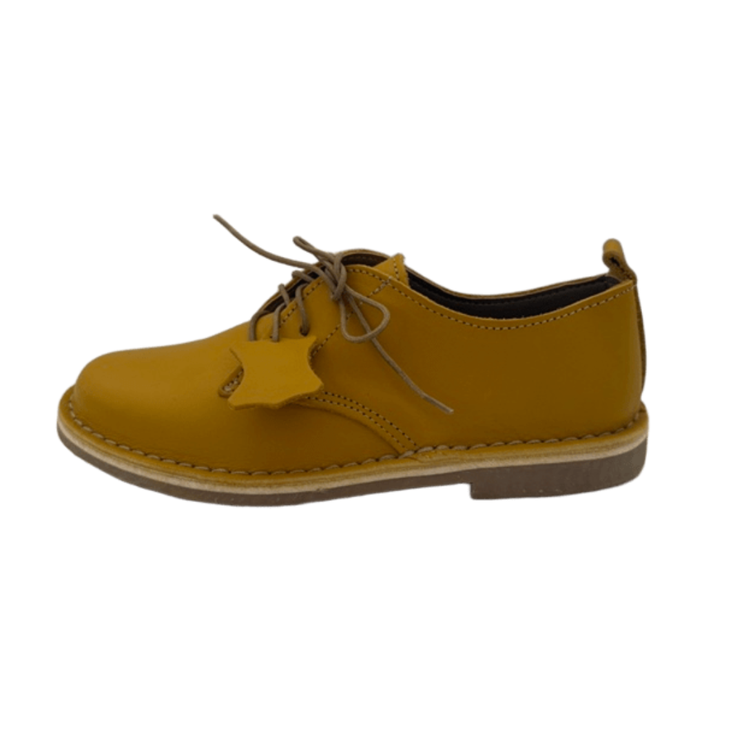 Yellow leather shoe on a white background from the side