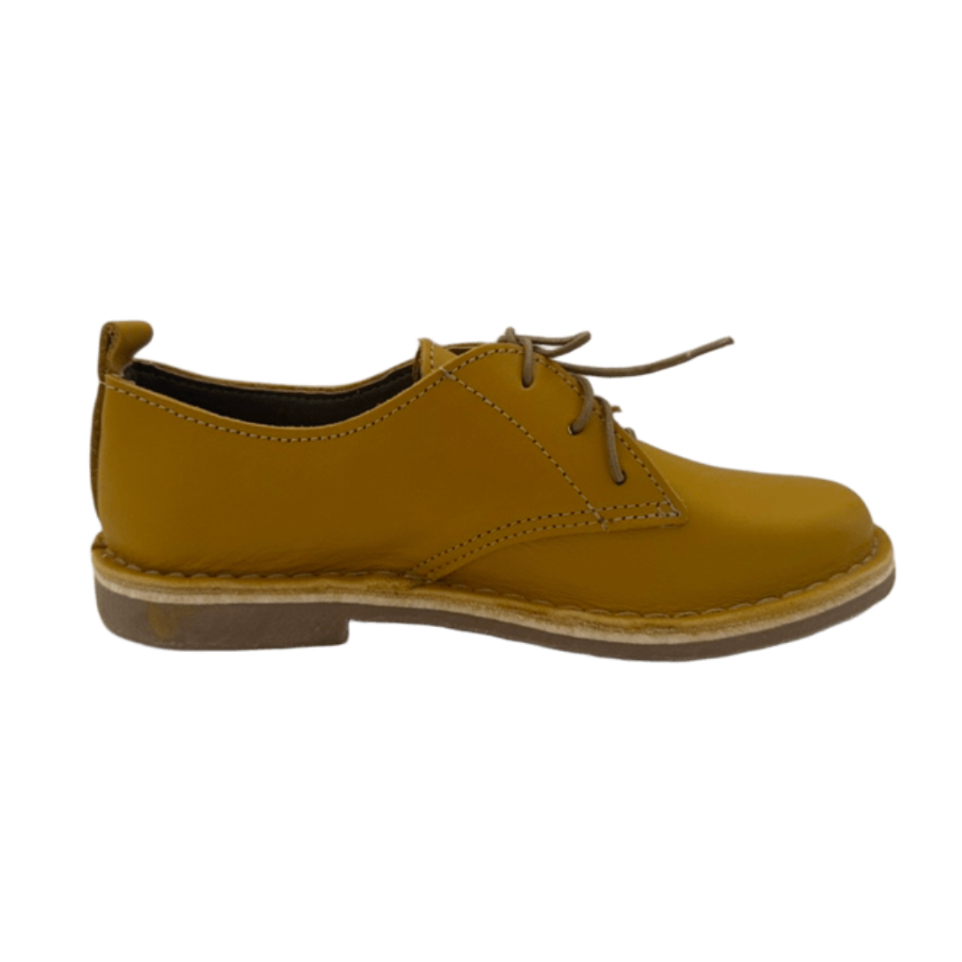 Yellow leather shoe on a white background from the side