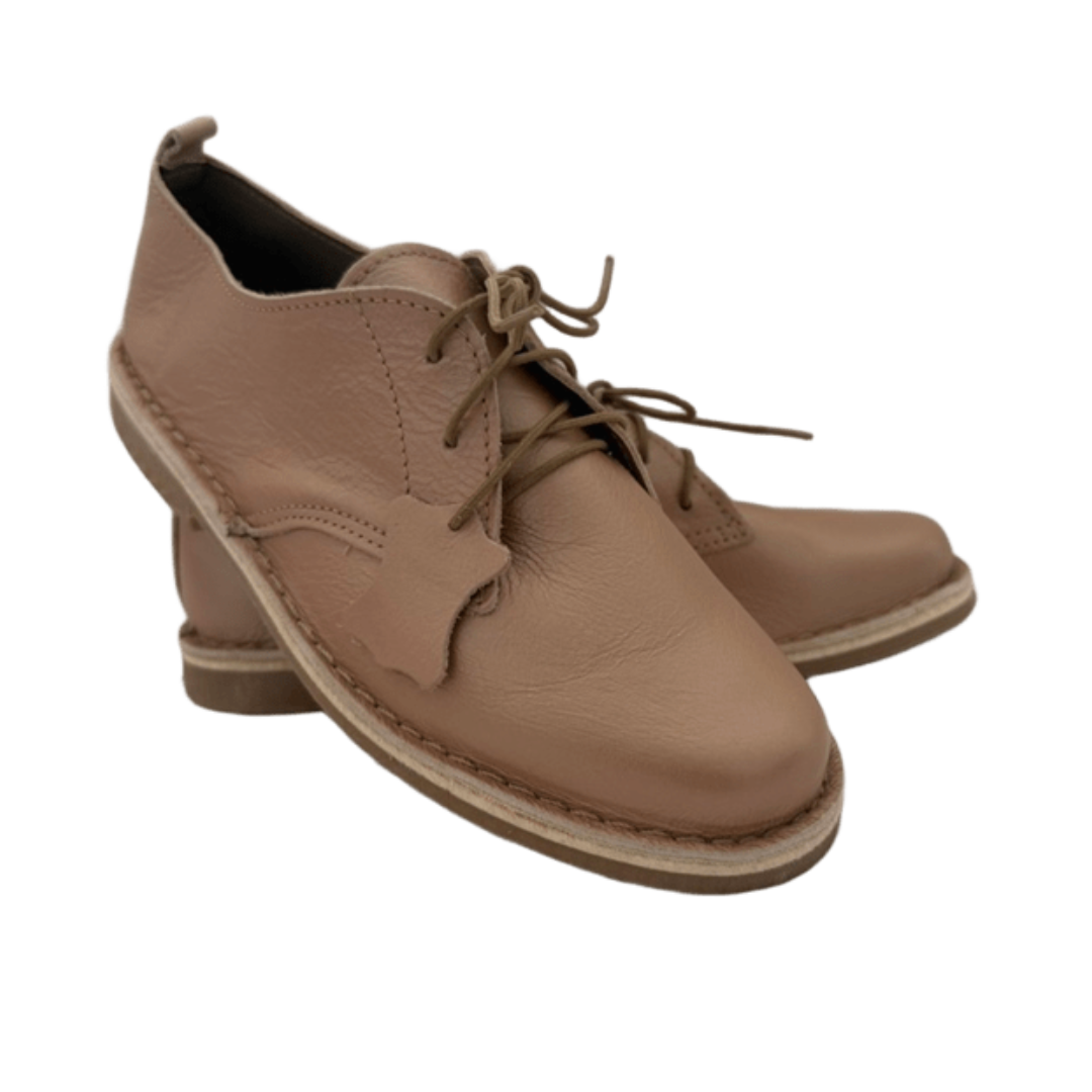Pair of rose gold leather shoes with laces on a white background from the front