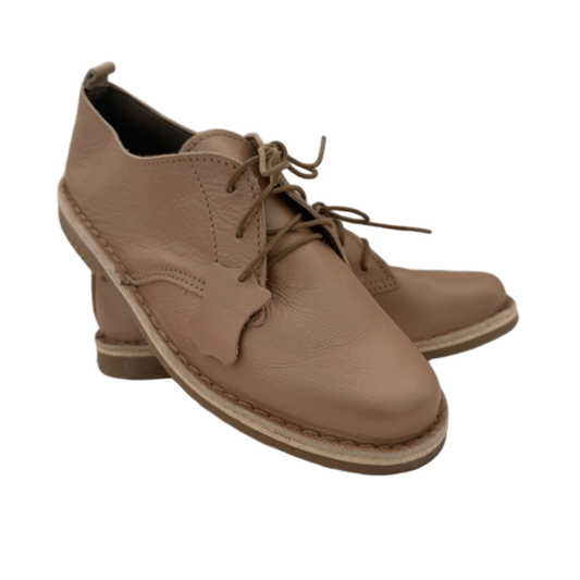 Pair of rose gold leather shoes with laces on a white background from the front